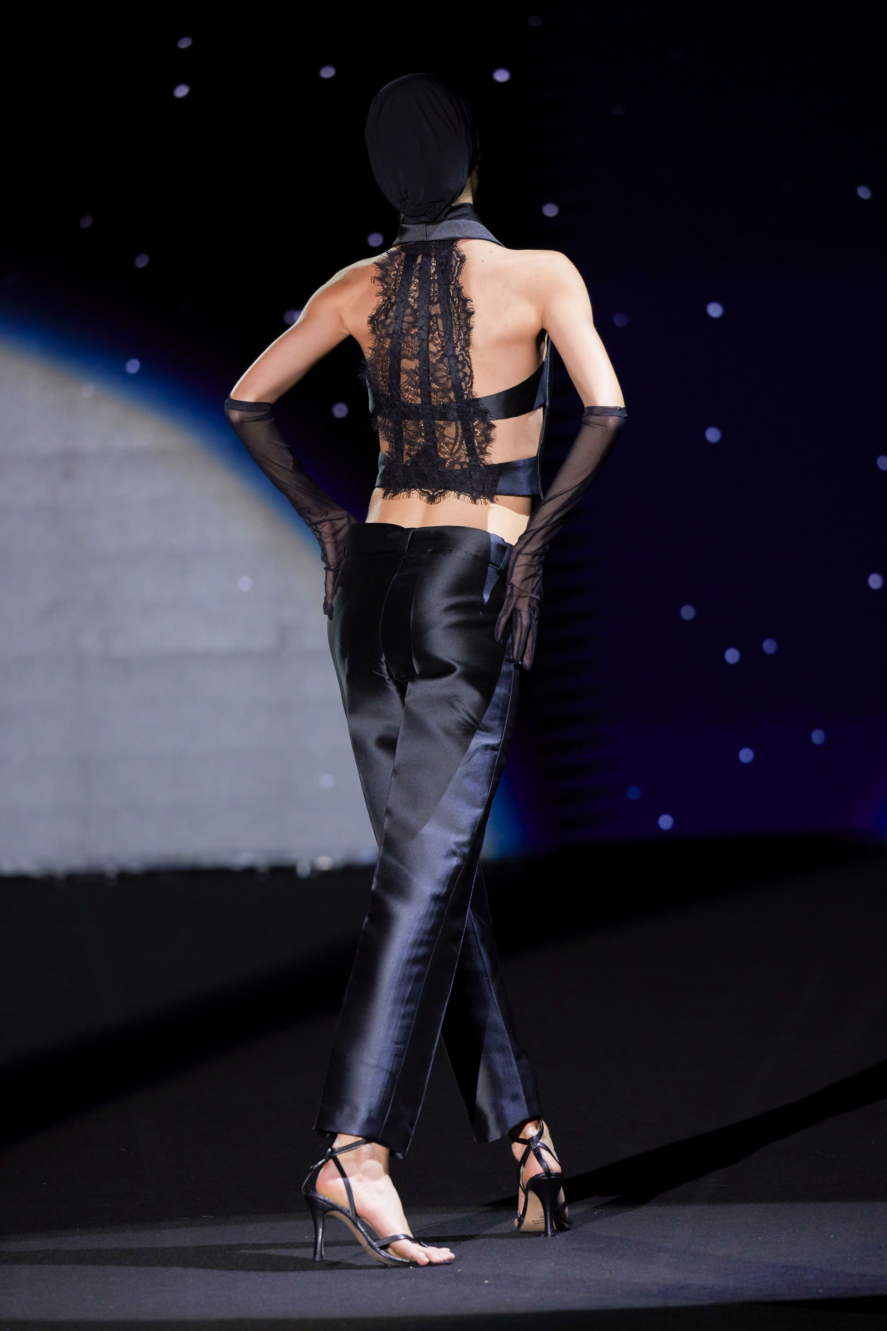 The back of the ensemble reveals its true alchemy: an architecture of minimalist sensuality and textile mastery.