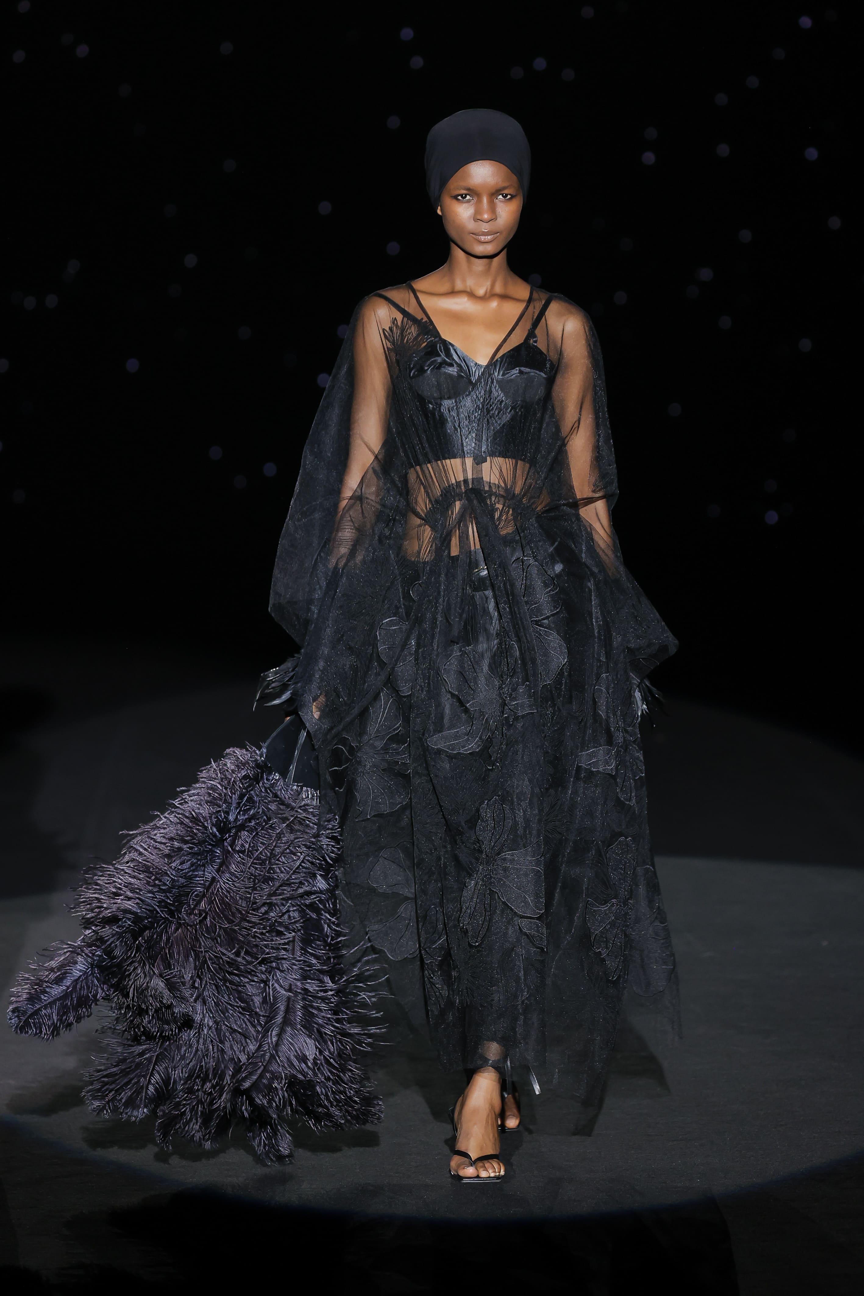 look radiates an ethereal sophistication, built on layers of embroidered tulle and transparencies that seem to float with every step.