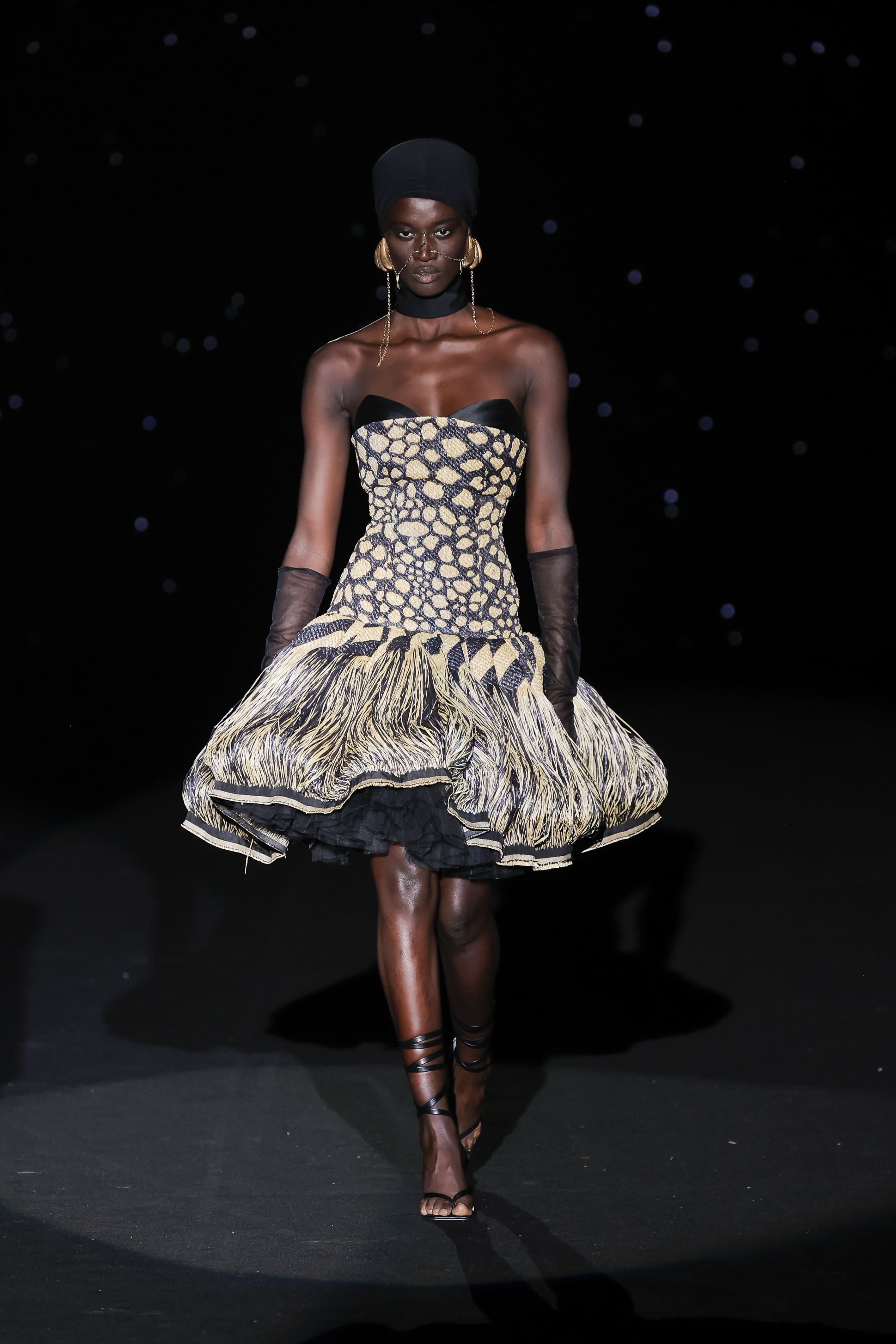 burst of energy and structure in the form of a tulip silhouette. This strapless dress fuses graphic rigour with sculptural voluptuousness.