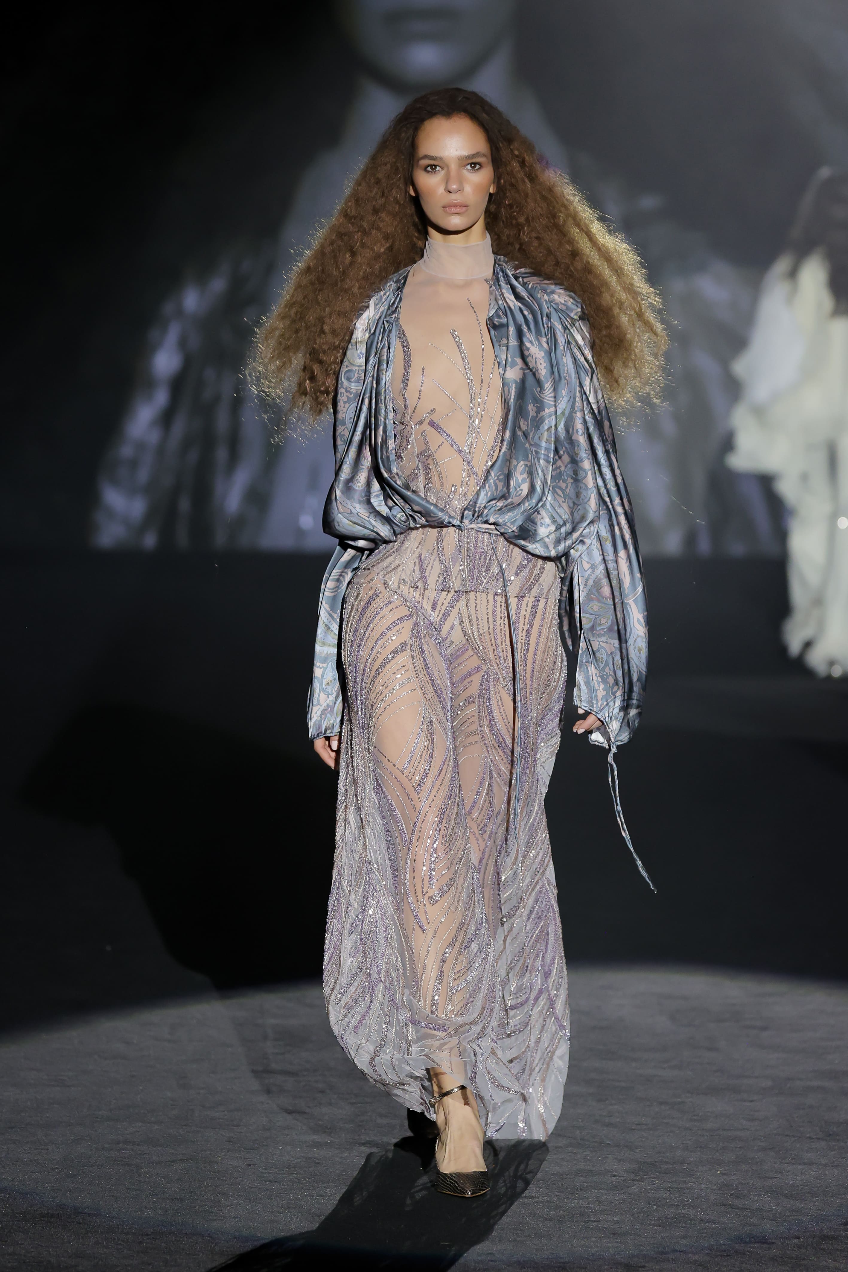 The catwalk look showcases an ethereal and sophisticated creation that fuses sensuality with stage drama.