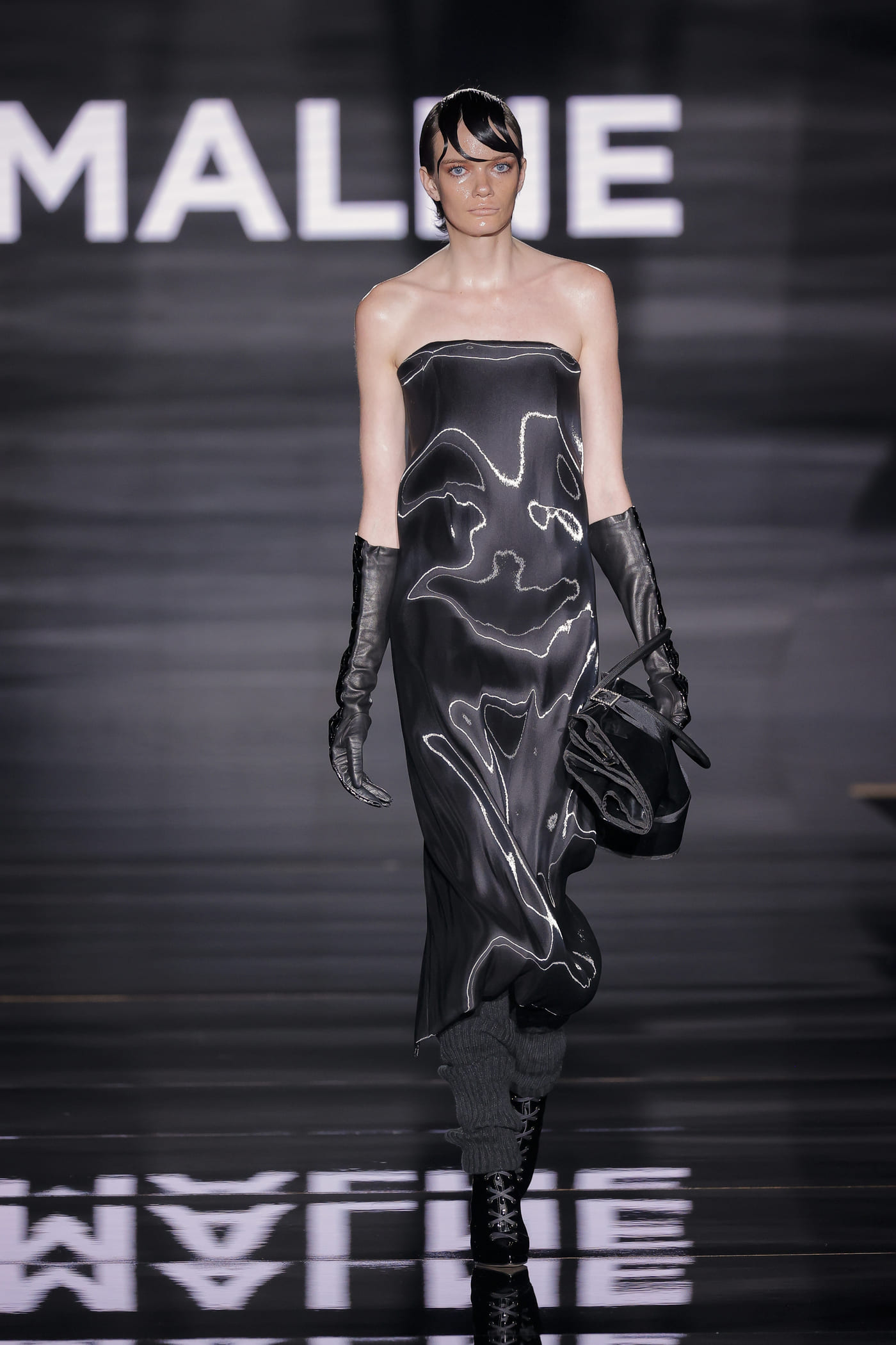 catwalk model in black costume with silver trimmings
