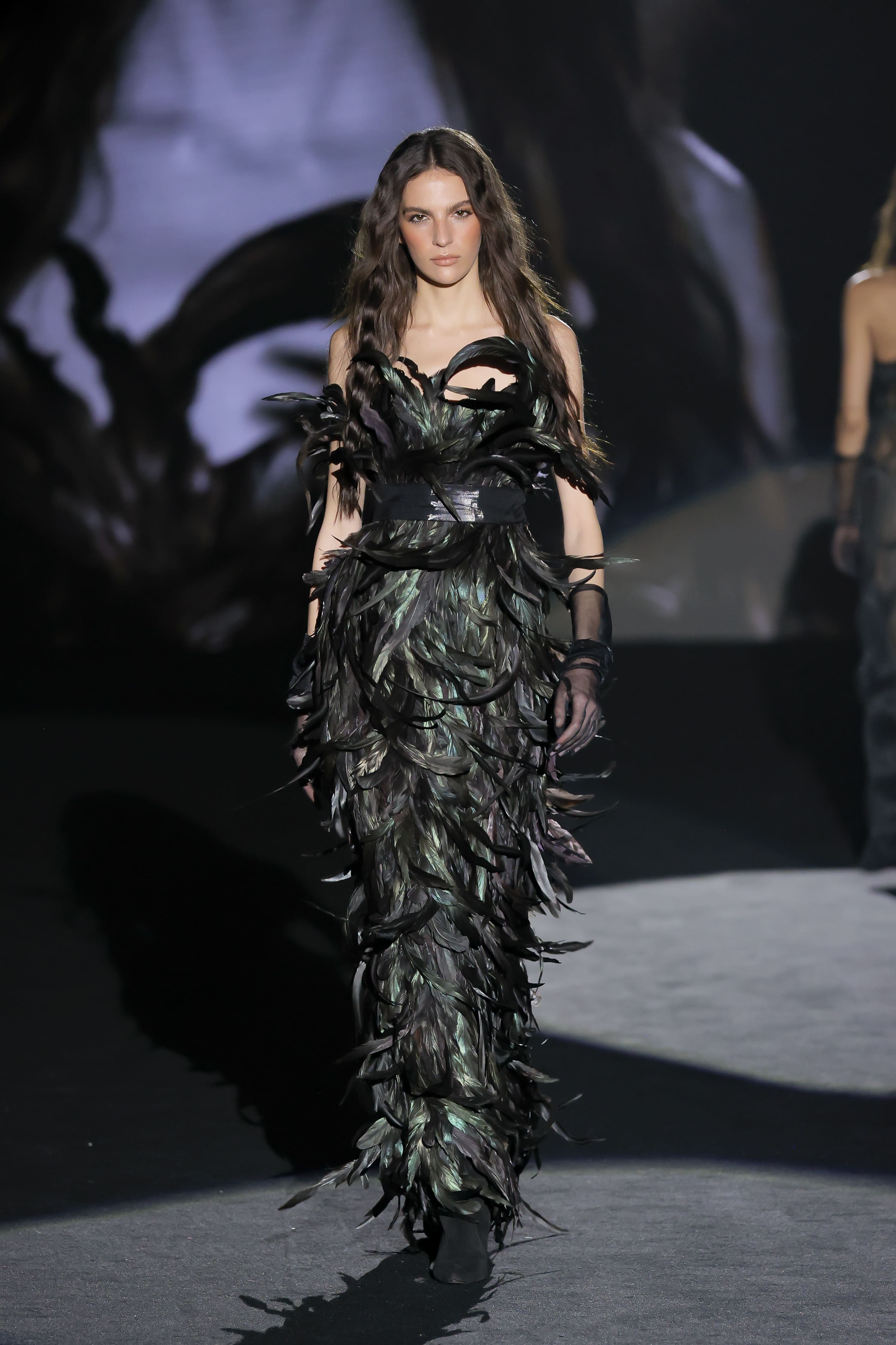 striking catwalk look evokes the majesty of a mythological bird, fusing fashion and performance art with hypnotic power