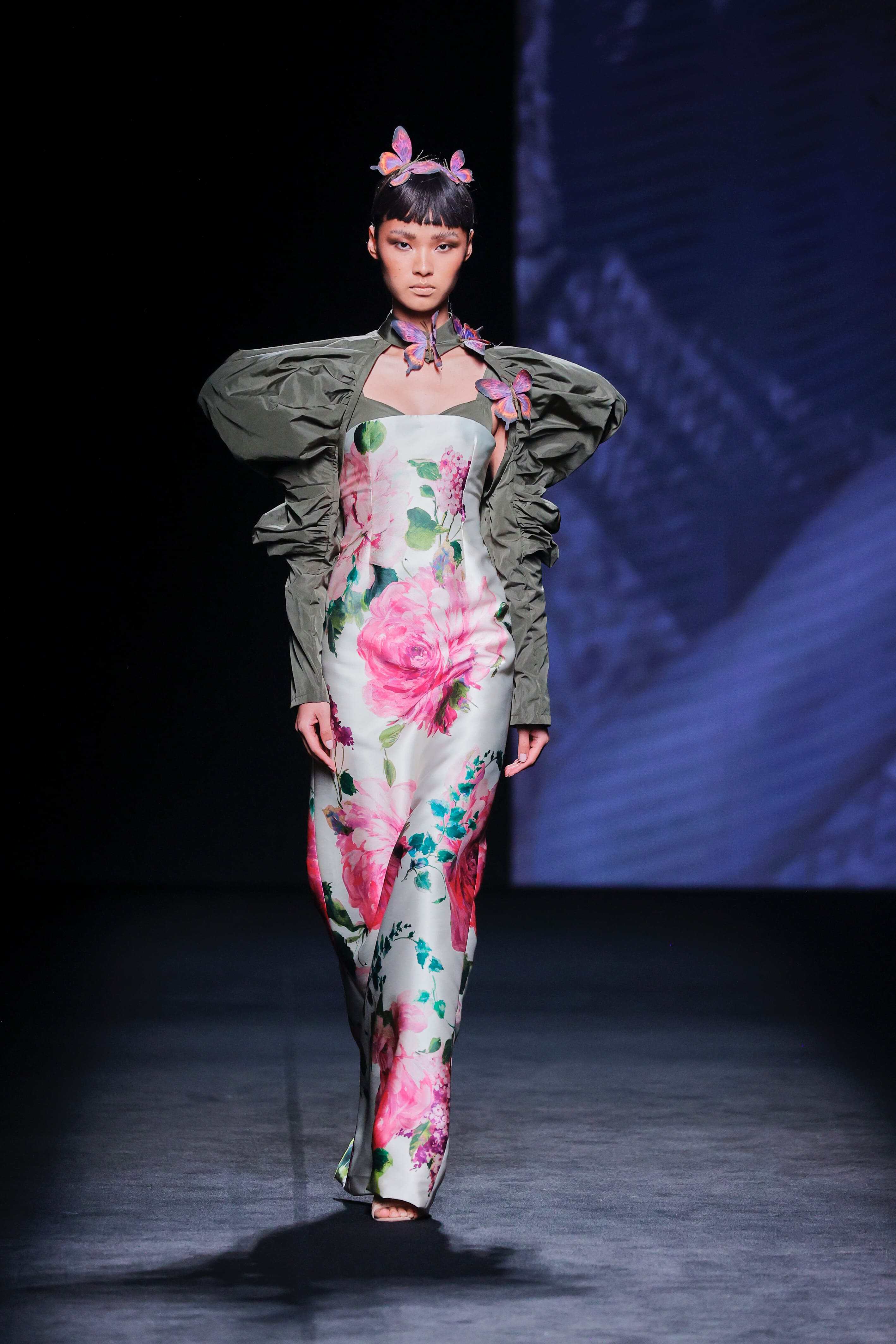Modelo en la pasarela con vestido largo estampado de flores de Malne en tonos rosa y verde.