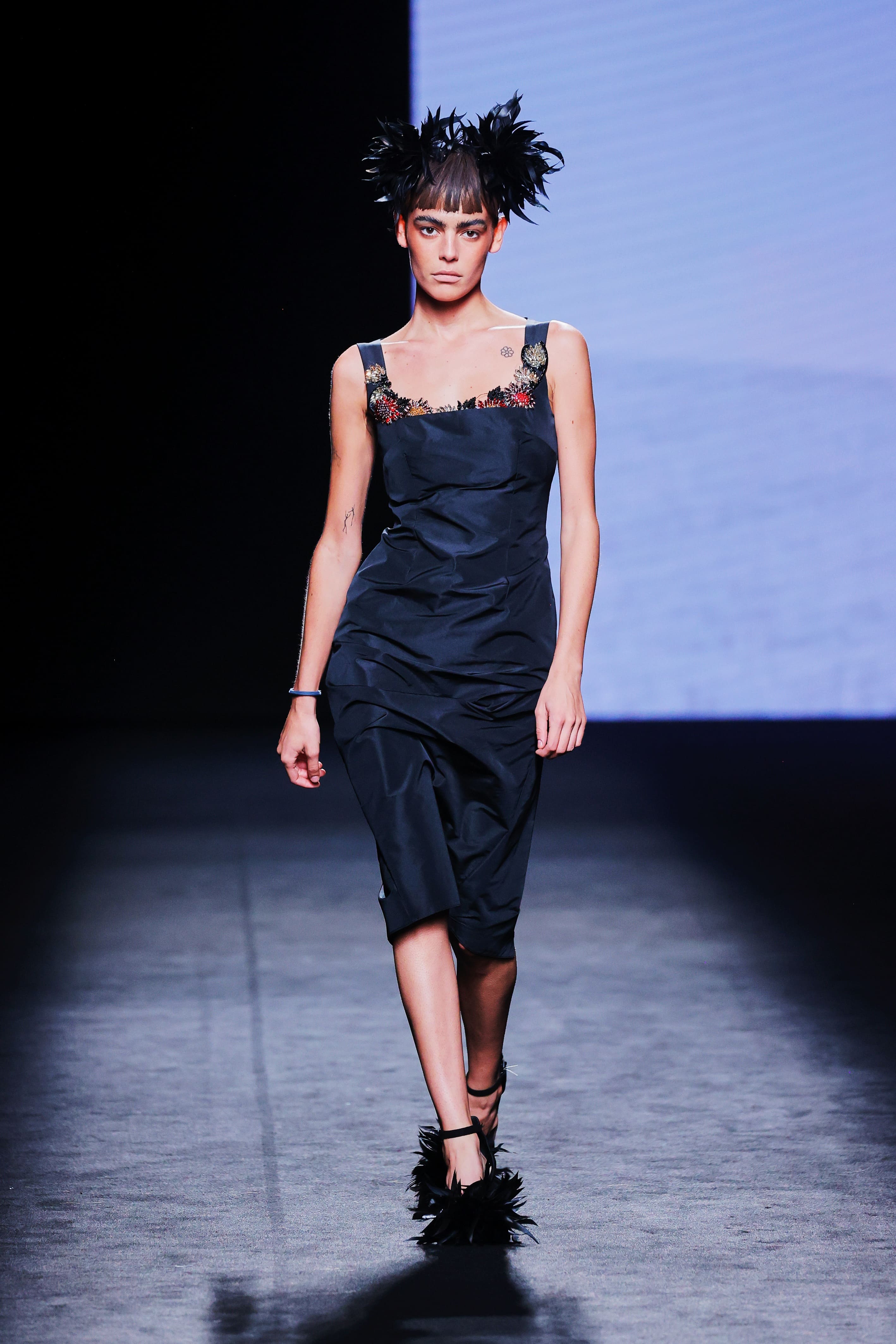 Modelo en la pasarela con vestido negro midi drapeado de Malne