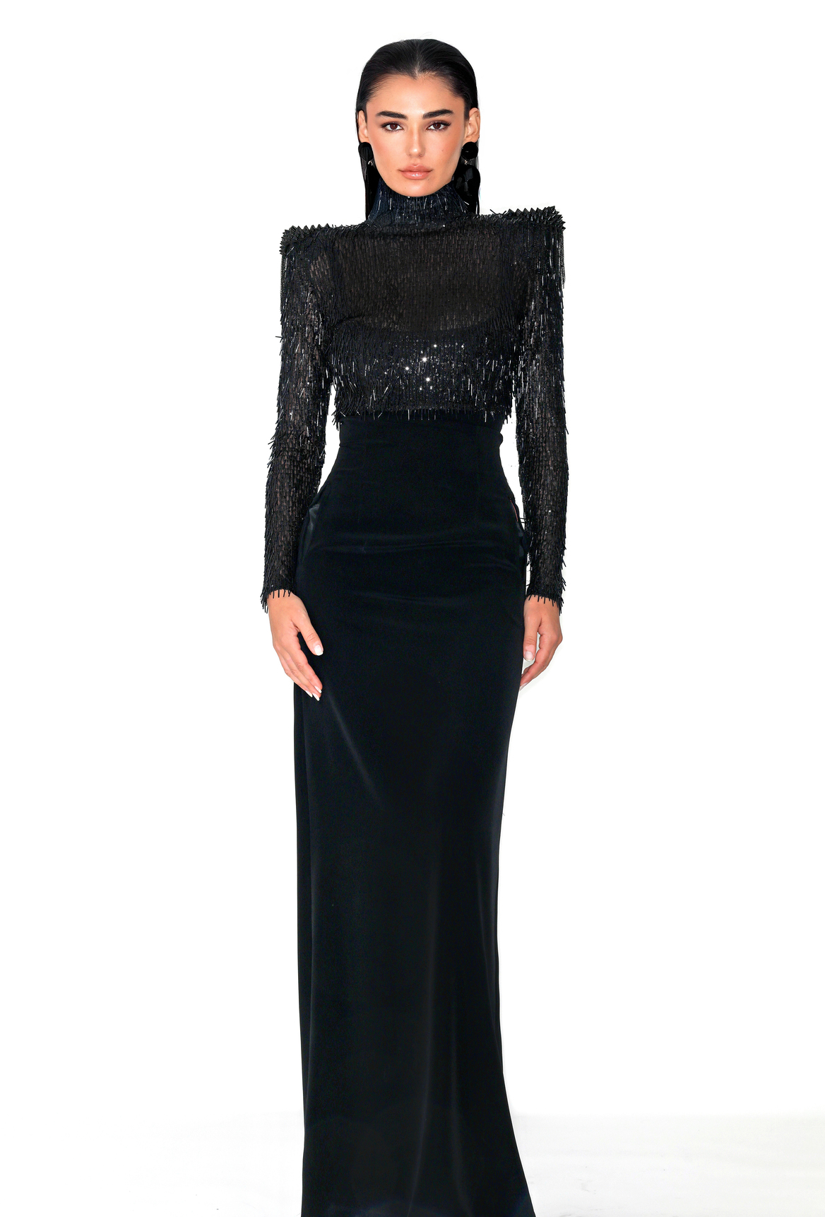 Long black dress by Malne with fitted skirt and semi-transparent bodice with high neck covered in fringe and sequins.