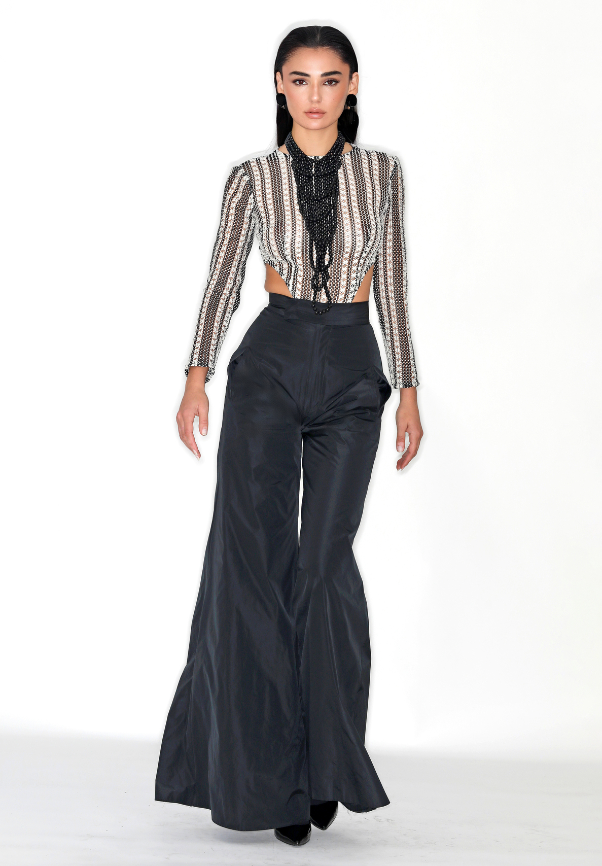 Pantalones negros de tiro alto con pernera ancha y corte palazzo que cae hasta el suelo - modelo