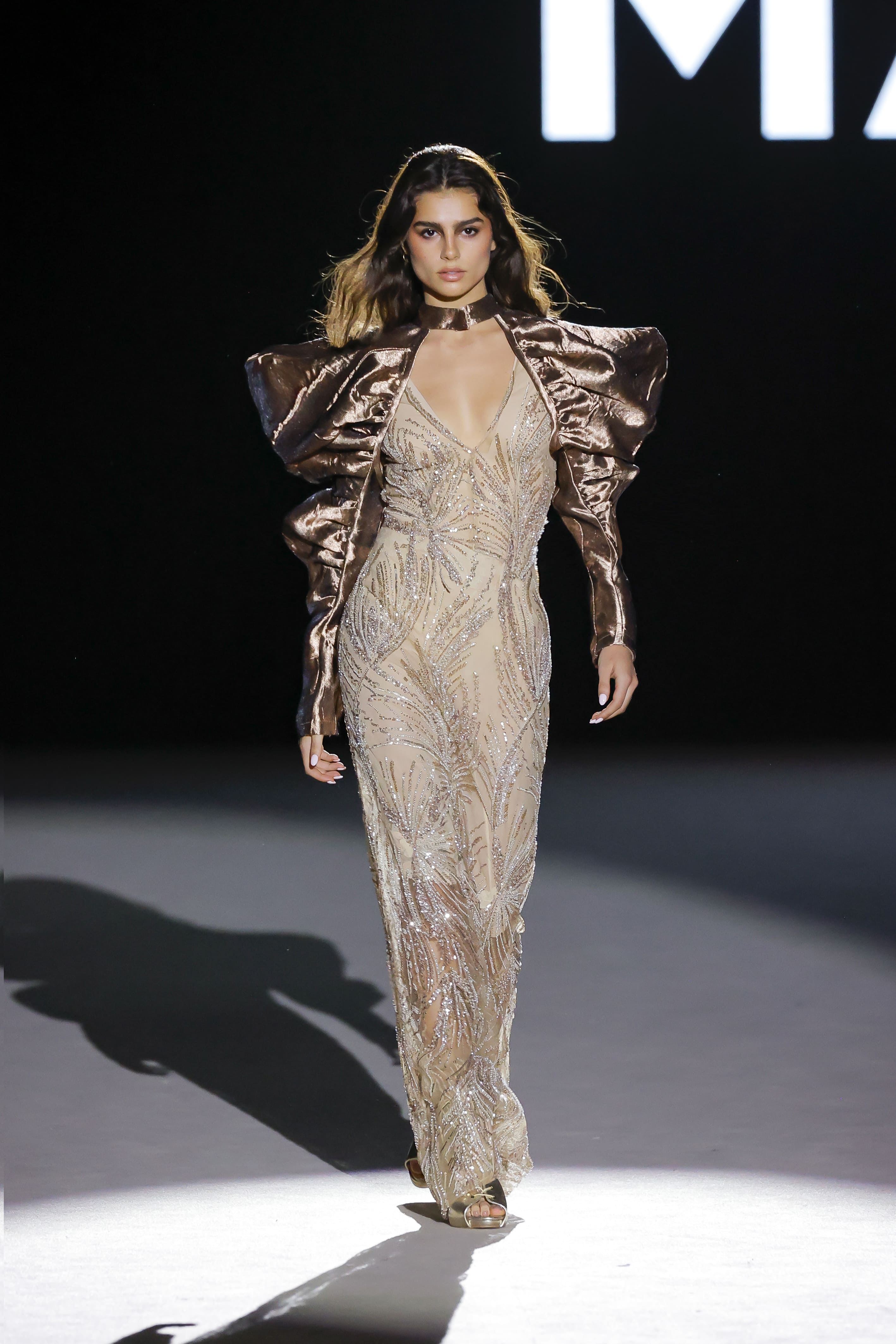 Modelo luciendo vestido largo beige con bordados brillantes y mangas voluminosas satinadas de Malne en la Mercedes-Benz Fashion Week Madrid marzo de 2026.
