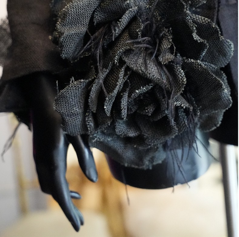 Detalle de diseño negro de Malne con flor textil deshilachada
